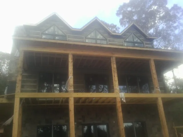 Dormers and porch framing on a large log home under construction — Roof Coating work by our crew in Lilliwaup